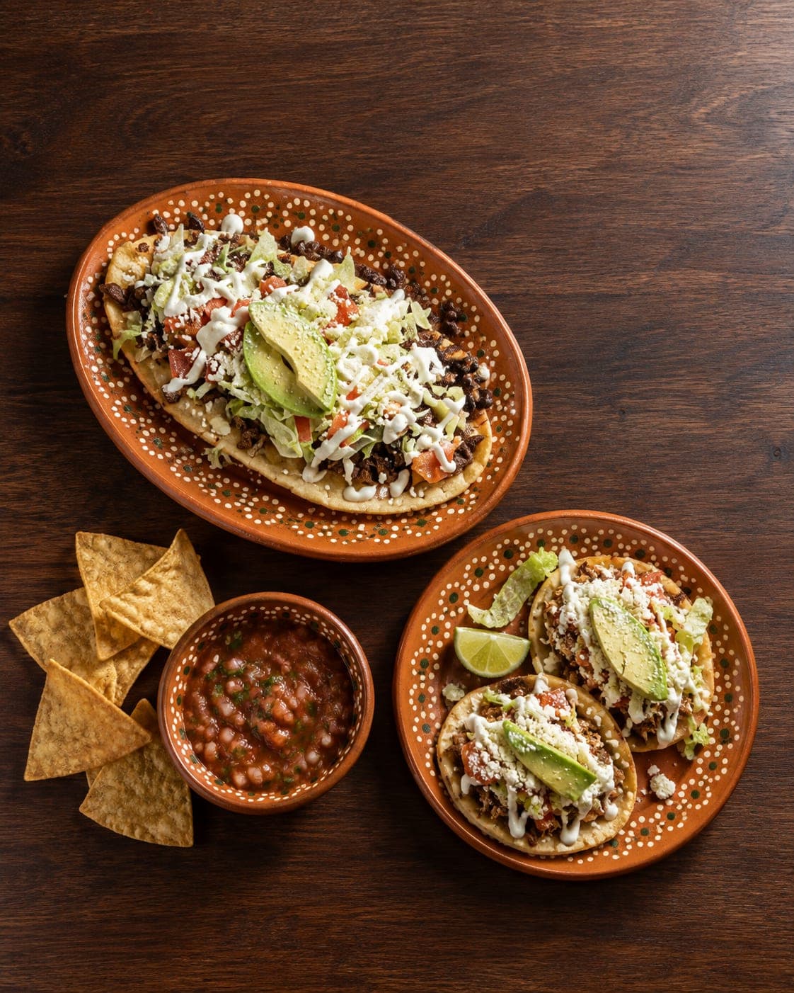 An overhead table spread with tacos, salsas, and shared sides.